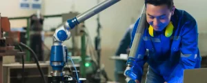 asian-male-engineer-specialist-with-measuring-machine-with-manipulator-armthreedimensional-coordinate-measurement-check-sizes-3d-check-sizes-parts-cmm-after-machining-process-hero-image